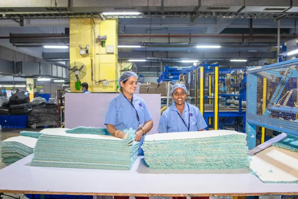 Pekerja perempuan mengoperasikan mesin di lini produksi pabrik tekstil modern